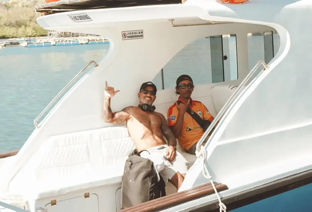 two men smiling sitting on the aquamarine speedboat ready for an adventure